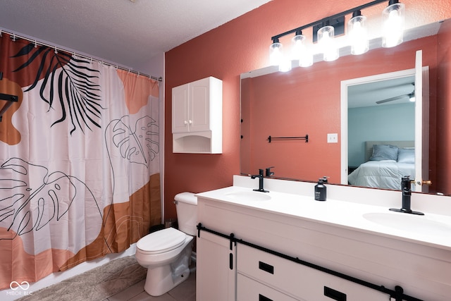 ensuite bathroom with double vanity, a sink, toilet, and connected bathroom