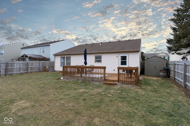 back of property with a yard, a storage shed, a fenced backyard, an outdoor structure, and a wooden deck