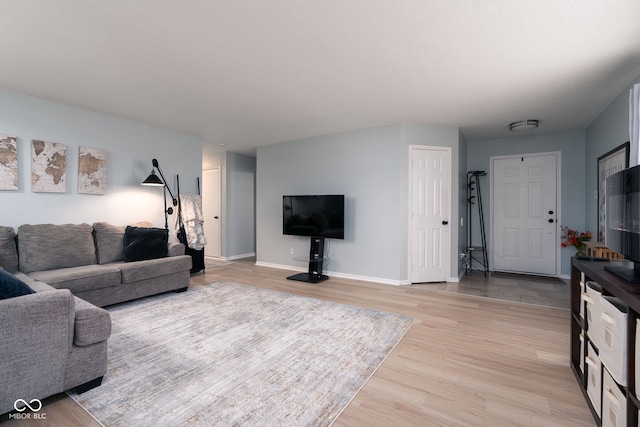 living area with light wood-style flooring and baseboards