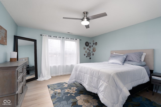 bedroom with light wood-type flooring, visible vents, and a ceiling fan