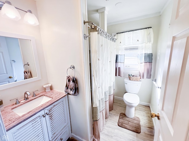 bathroom with curtained shower, toilet, wood finished floors, vanity, and baseboards