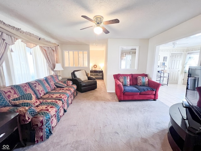 living area featuring carpet, ceiling fan, and a textured ceiling