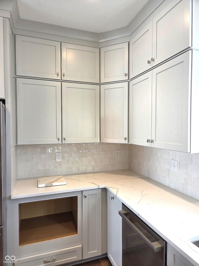 kitchen featuring light stone counters, decorative backsplash, and dishwasher