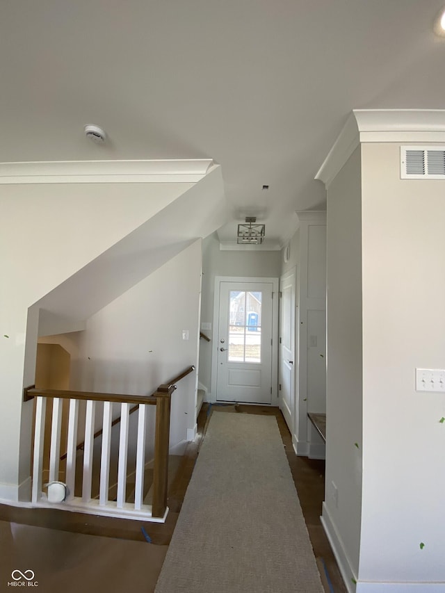 interior space featuring baseboards, dark wood-type flooring, visible vents, and crown molding