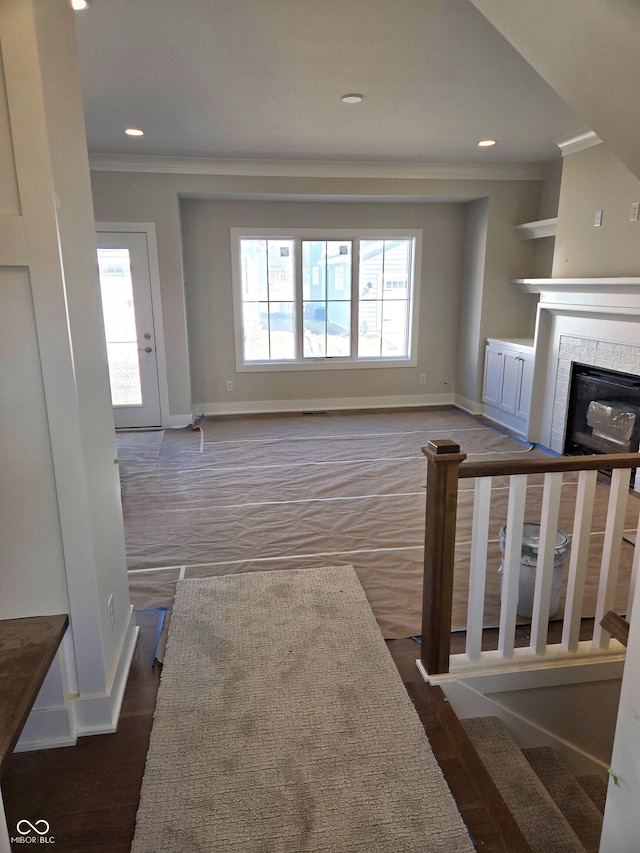 living area with ornamental molding, a wealth of natural light, a fireplace, and baseboards