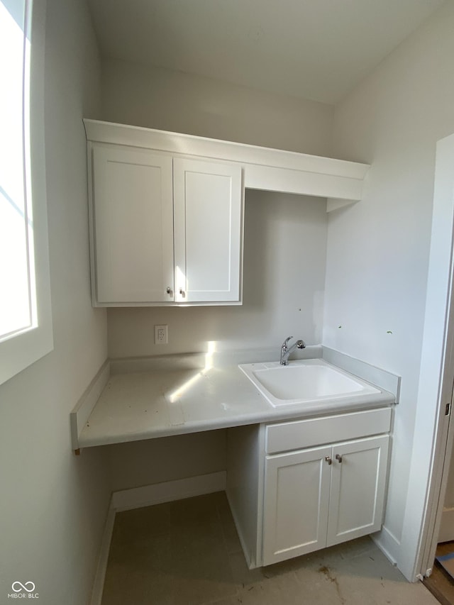 laundry area with a sink and baseboards