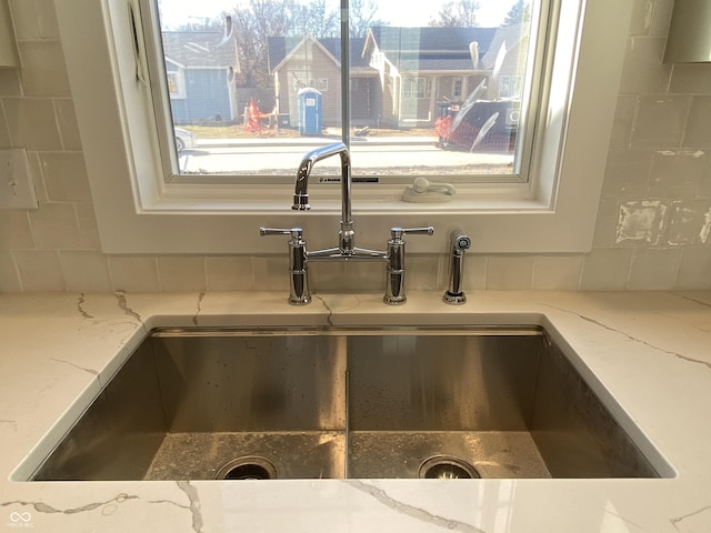 interior details featuring light stone counters and a sink