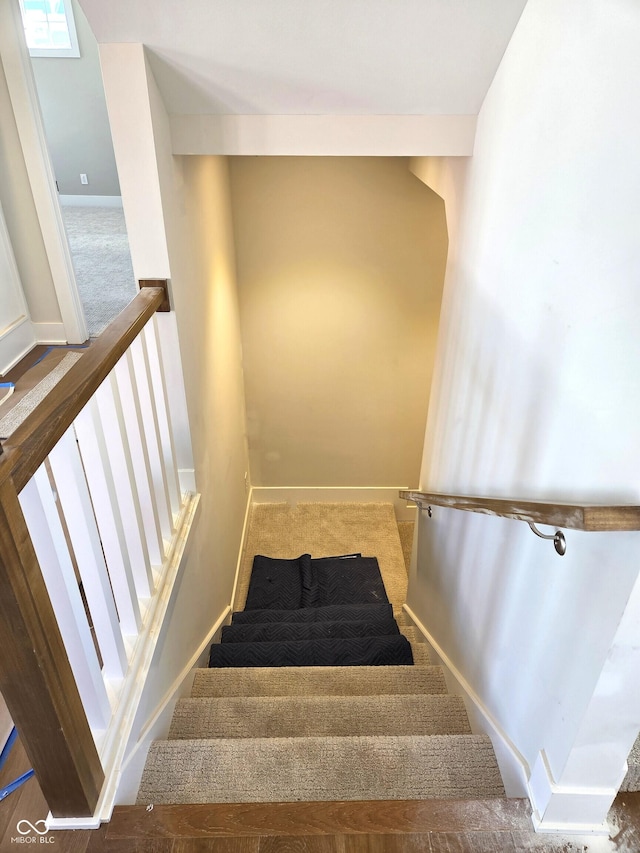 staircase featuring carpet floors and baseboards