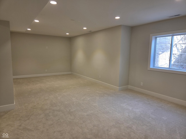 unfurnished room with recessed lighting, baseboards, light colored carpet, and visible vents