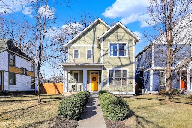 view of front facade with a porch, a front yard, and board and batten siding