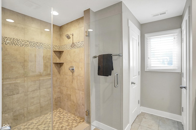 full bath featuring tile patterned flooring, a shower stall, baseboards, and visible vents