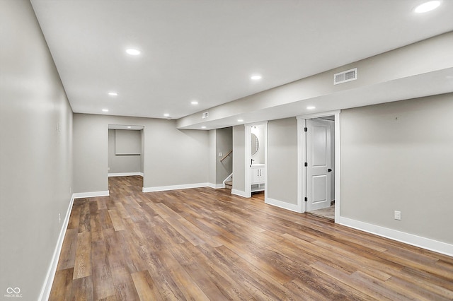 finished below grade area with recessed lighting, wood finished floors, visible vents, and baseboards