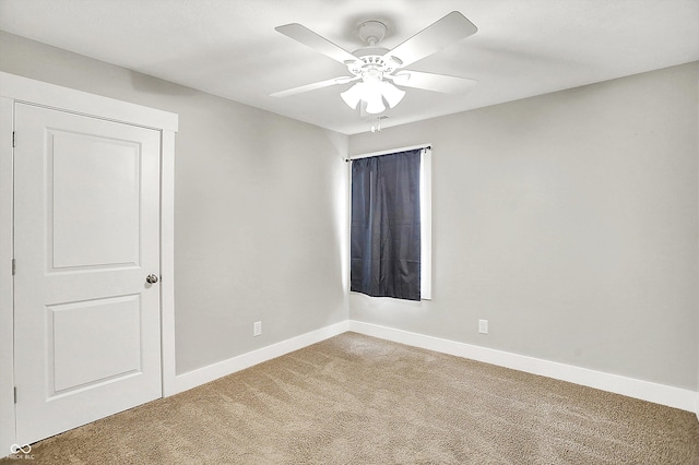 carpeted empty room featuring baseboards and ceiling fan