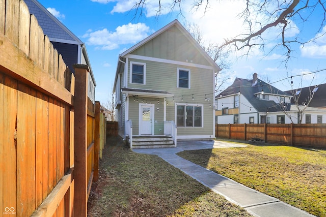 back of house featuring a yard, a patio, and a fenced backyard