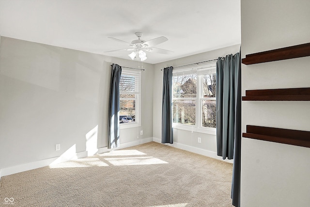 carpeted spare room with baseboards and a ceiling fan