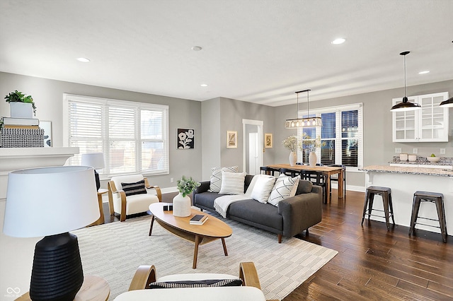 living area with recessed lighting, baseboards, and dark wood-style flooring