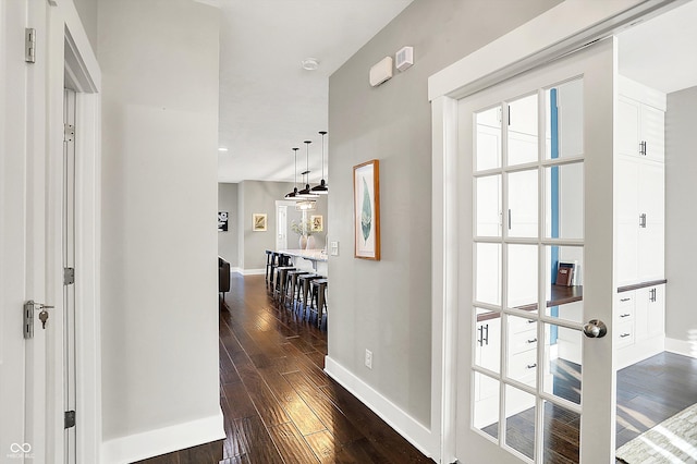 hall with dark wood finished floors and baseboards