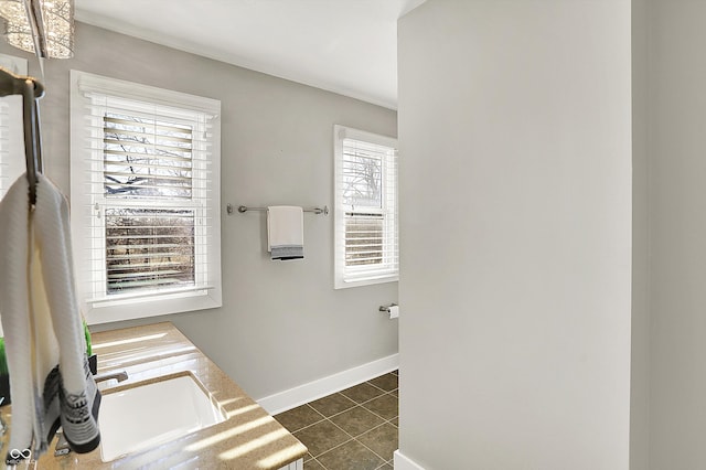 bathroom with tile patterned floors, baseboards, and a sink