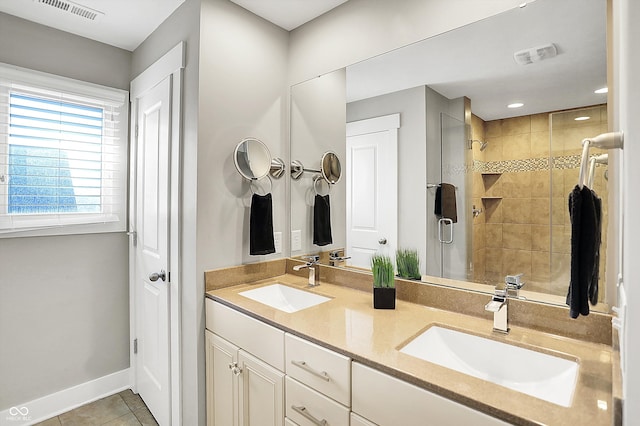 bathroom featuring tile patterned floors, visible vents, a shower stall, and a sink