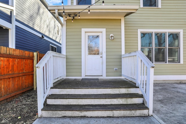 entrance to property featuring fence and covered porch