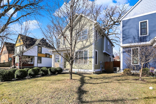 view of side of property featuring central air condition unit and a yard