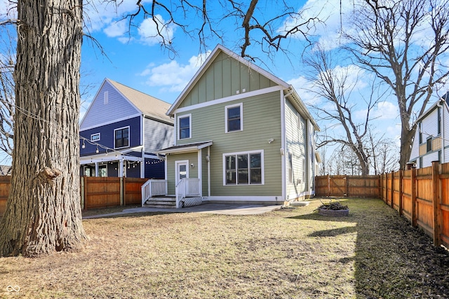 back of house featuring a patio area, board and batten siding, and a fenced backyard