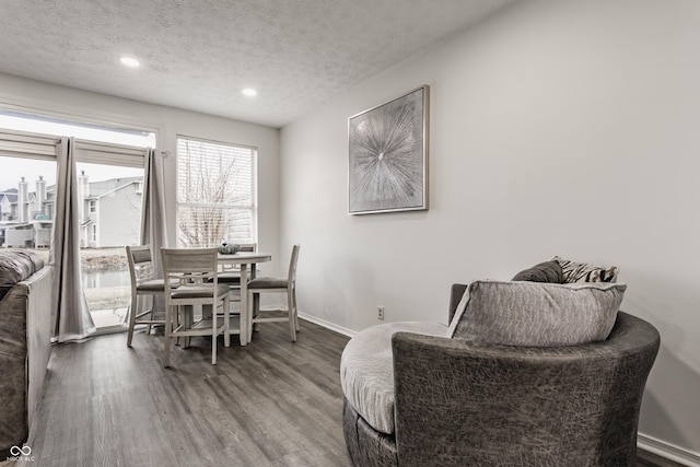 dining space with recessed lighting, a textured ceiling, baseboards, and wood finished floors