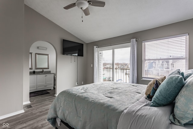 bedroom with baseboards, visible vents, lofted ceiling, wood finished floors, and access to outside