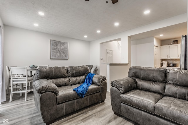 living area with light wood-style floors, recessed lighting, and ceiling fan