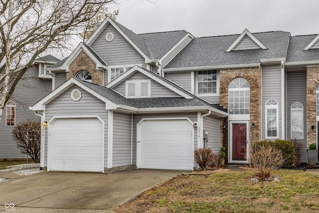 view of front of home with a garage, driveway, and roof with shingles