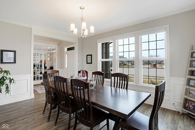 dining room featuring a notable chandelier, wainscoting, dark wood finished floors, and crown molding