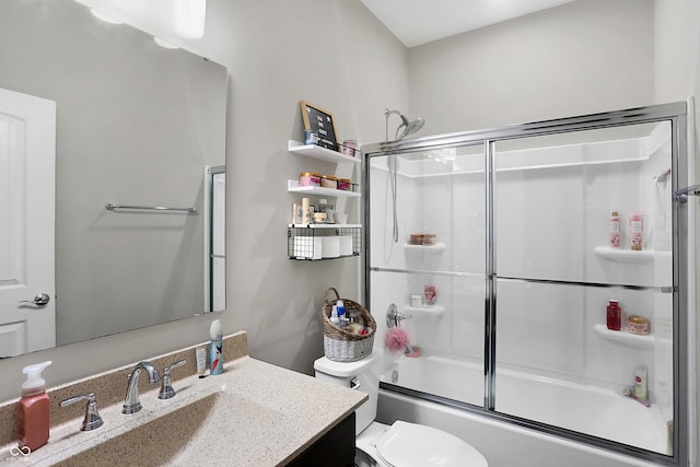 bathroom featuring toilet, combined bath / shower with glass door, and vanity