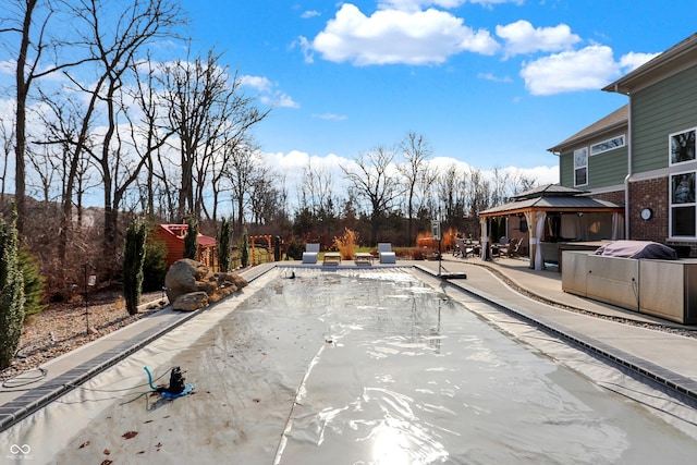 view of swimming pool with a patio and a gazebo