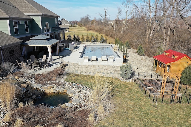 outdoor pool with a fire pit, a patio, a gazebo, fence, and a yard