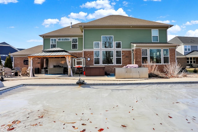 rear view of property with brick siding, a patio, outdoor lounge area, and a gazebo