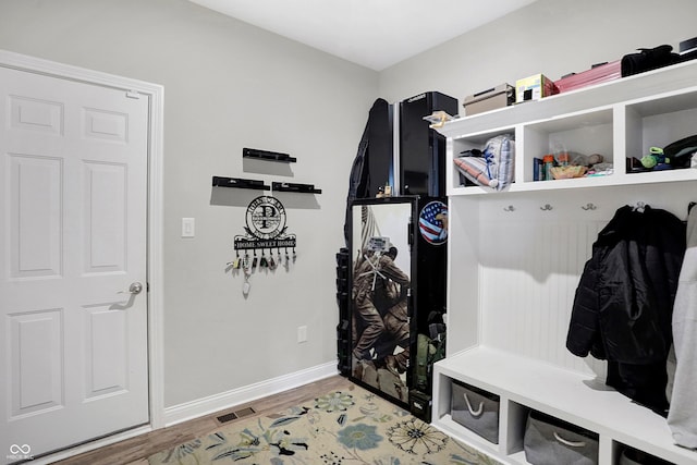 mudroom with light wood-type flooring, visible vents, and baseboards