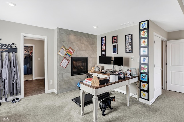 home office featuring recessed lighting, visible vents, a tiled fireplace, carpet flooring, and baseboards