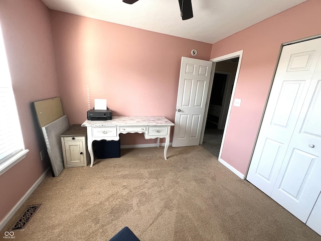 office with visible vents, light carpet, baseboards, and ceiling fan