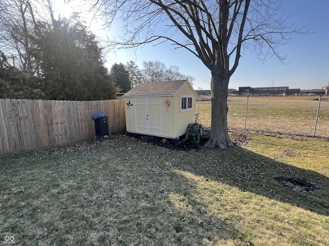 view of yard with a fenced backyard, an outdoor structure, and a shed