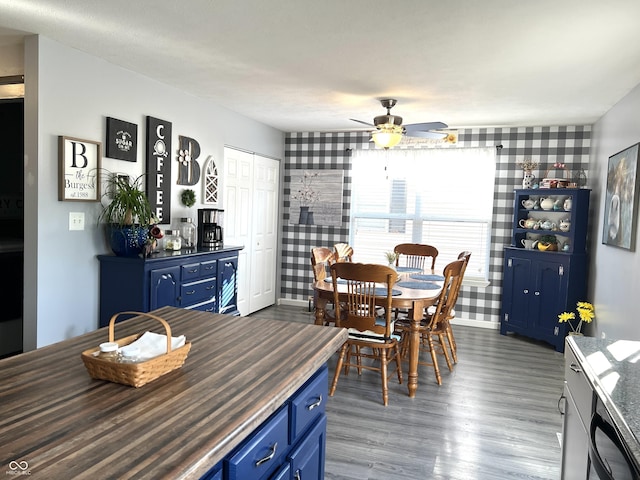 dining space with ceiling fan and dark wood-style floors