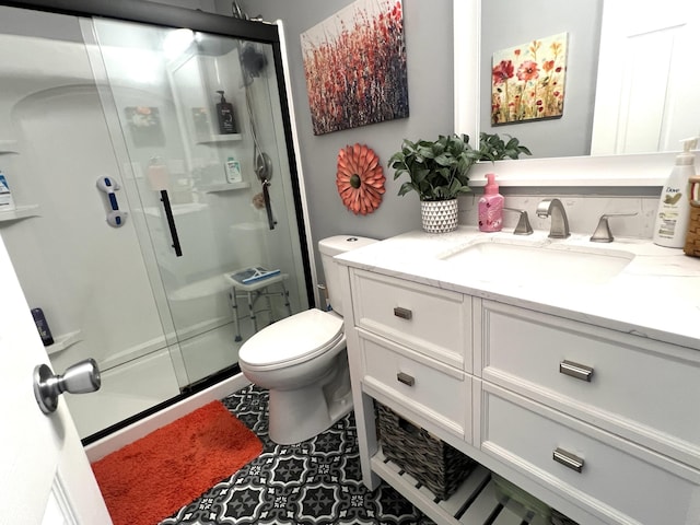 bathroom featuring vanity, toilet, and a stall shower