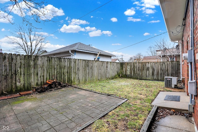 view of yard with a patio area, a fenced backyard, and central AC