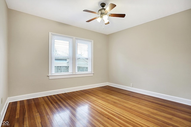 empty room featuring hardwood / wood-style flooring, baseboards, and a ceiling fan