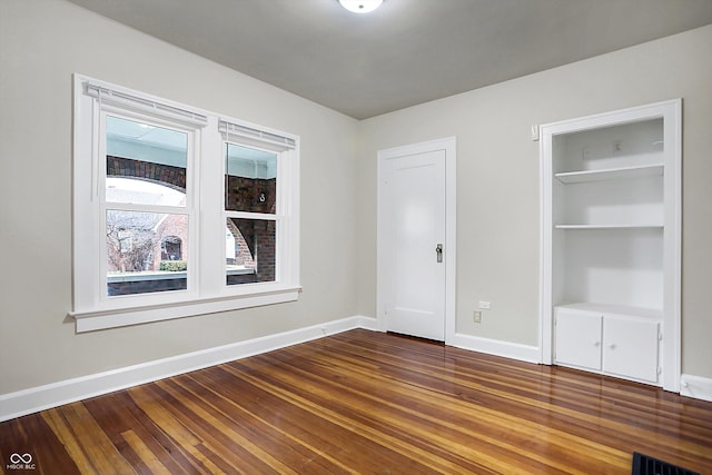 interior space featuring baseboards, a closet, visible vents, and dark wood-style flooring