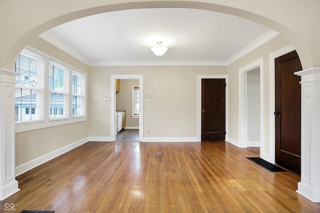 unfurnished room featuring baseboards, crown molding, visible vents, and light wood finished floors