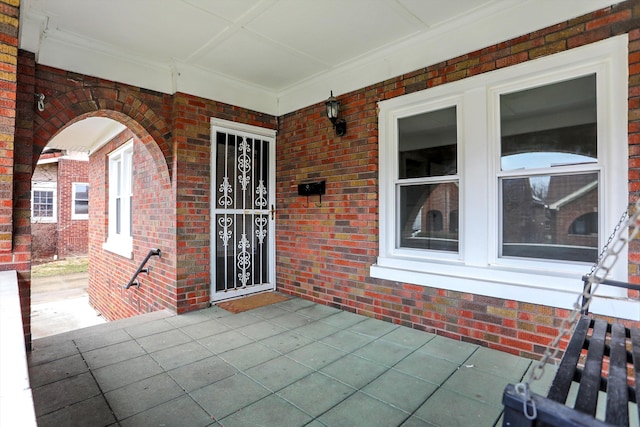 doorway to property featuring brick siding