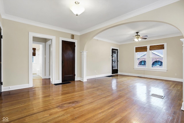 interior space featuring light wood-type flooring, baseboards, visible vents, and crown molding