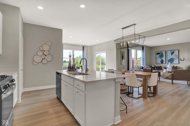 kitchen featuring light wood-style flooring, stainless steel appliances, a sink, and open floor plan