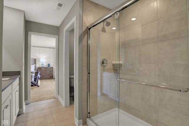 ensuite bathroom featuring toilet, ensuite bathroom, tile patterned floors, vanity, and a shower stall