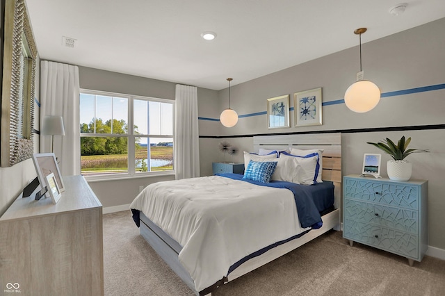 bedroom with a water view, carpet, visible vents, and baseboards